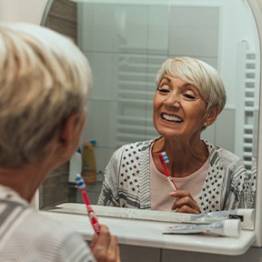 Patient with dentures in Ramsey looking in mirror