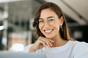 Woman with glasses giving a confident smile